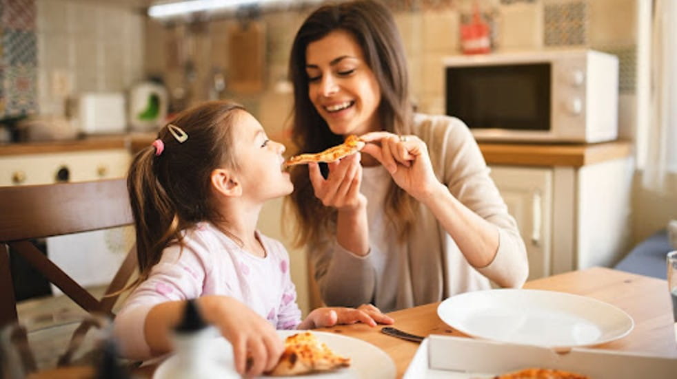 Mother feeding daughter